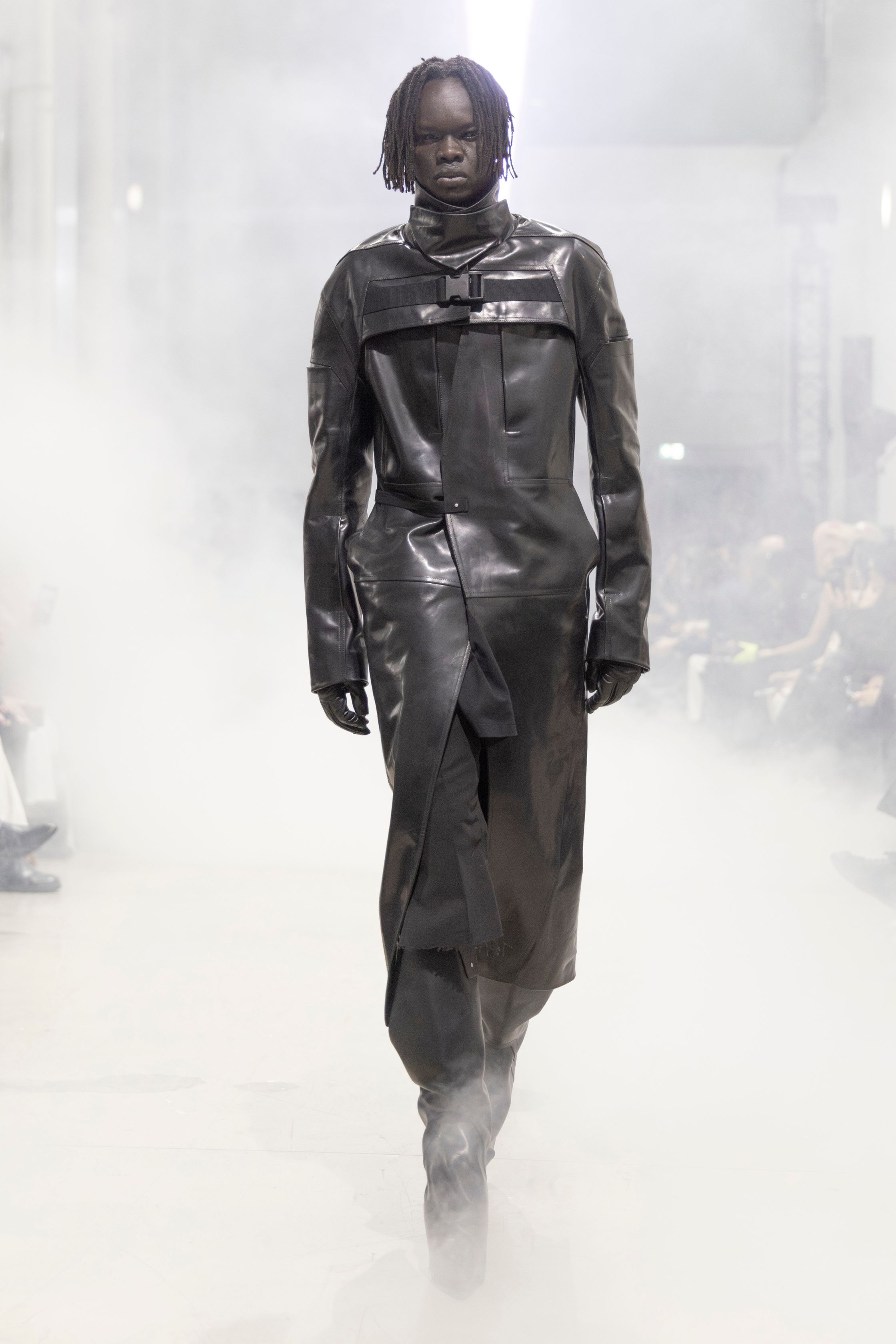Rick Owens 2026秋冬延续其末世感与宗教式仪式美学。极端肩部结构、皮革与毛感材质在烟雾弥漫的空间中塑造出超越性别的强势身体。系列不再讨论日常，而是关于存在、力量与脆弱的对立统一。行走仿佛一种宣誓，服装成为精神铠甲，彰显Rick Owens一贯的黑暗崇高感-顽石频道趋势研究